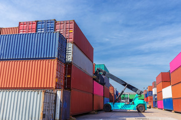 Forklift truck working in container warehouse with beautiful sky for logistics shipping, import export or transportation.