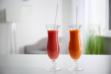 Glasses of tasty smoothies on white table