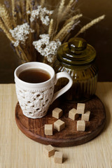 Cubes of brown sugar on the kitchen table. Rustic still life with wooden and glass utensils.