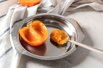 Plate with sweet ripe persimmon on table