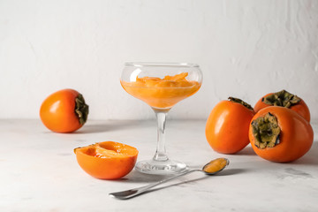 Glass with sweet persimmon jam on table
