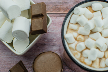 Cocoa drink with spices, zephyr on wooden background