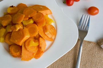 Orange vegetable stew with a fork and red tomatoes