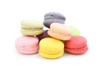 Close up many colorful fresh macarons pile isolated on white background, look delicious