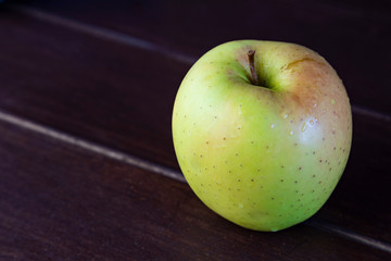 juicy green apple and space for text on wooden background.