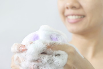 Close up Asian woman make bubble facial foam for cleansing her face skin and take a bath, have copy space