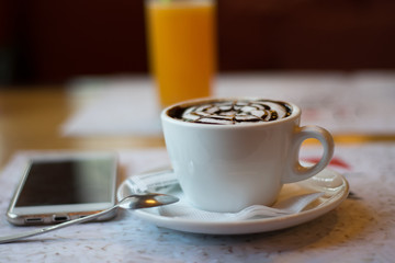 still life with a cup of flavored cappuccino, a phone on the background of a glass of orange juice. wallpaper