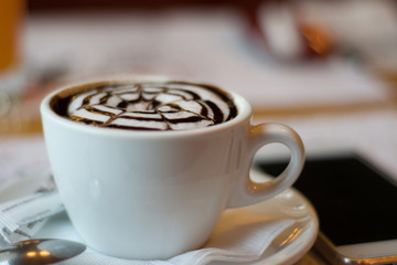white cup with cappuccino, latte, coffee, mobile phone on a wooden table. wallpaper