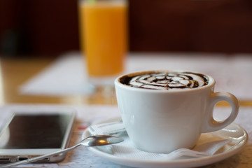 still life with a cup of flavored cappuccino, a phone on the background of a glass of orange juice. wallpaper