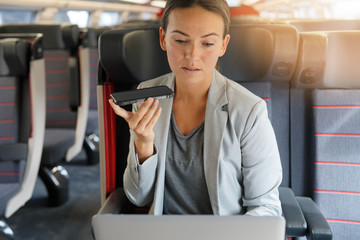  Businesswoman in first class on a train with her cellphone