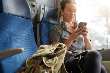 Relaxed woman texting on train