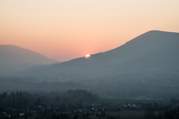 Obraz premium sunset over hill with colorful sky and village bellow