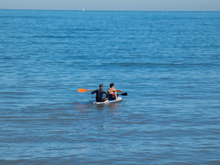 Fototapeta premium Man and woman swims on kayak in the sea . Kayaking concept