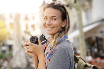 Attractive young woman taking photographs on SLR