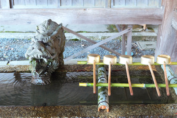 A Shinto Temizuya Pavillion cleaning ritual ( A traditional Water Purification Basin) with decorated dragon fountain in the temple in Japan.
