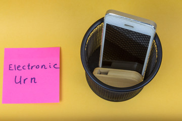 Electronic equipments in trash can with the words electronic urn