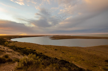 View of a shore with a lake on sunset