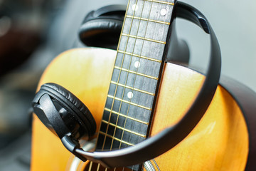  Wooden yellow guitar and headphones. Recording concept of musical instruments.