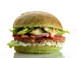 Fresh homemade delicious burger with a spinach bun. Isolated on white.
