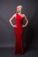 Full length portrait of beautiful woman with blond hair wearing red dress