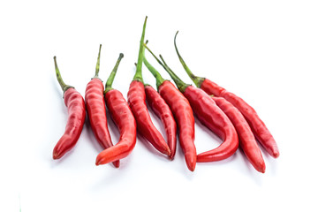 mini pods of red chili peppers hot additive to meat and chicken giving flavor to a group of vegetables on a white background