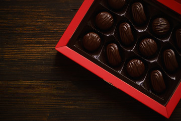 Candy box flatlay on wooden background. Festive atmosphere with chocolate treats.