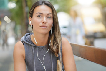 A young woman looking serious with earbuds