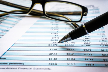 Accounting business concept. Glasses with accounting report and financial statement on desk