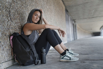 Woman in sportswear sitting down in a tunnel