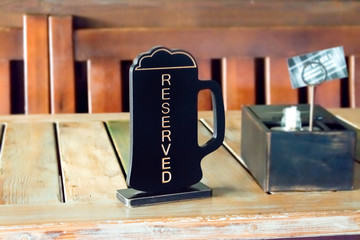 Beer pinta reserved sign on wooden table in pub, cafe, restaurant. Order lunch, dinner, breakfast...