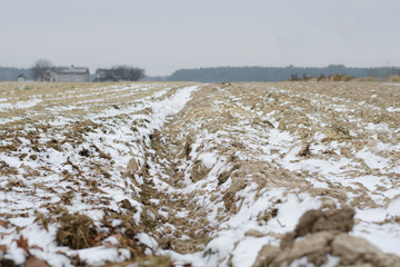 Plowed land in winter with deep furrows sprinkled with snow