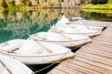 Fototapeta na wymiar Boat rental for tourists on a mountain lake in the valley of Nuria, Spain. Pyrenees ridge.