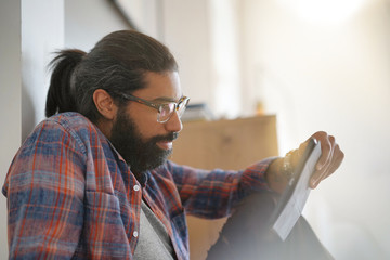 Fototapeta premium Hipster guy sitting on floor, connected with digital tablet