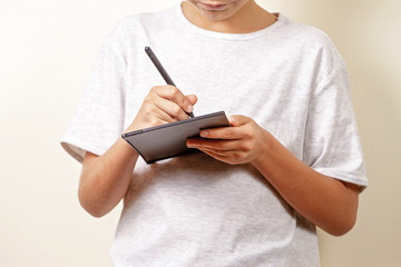 Kid drawing with graphic tablet and stylus pen