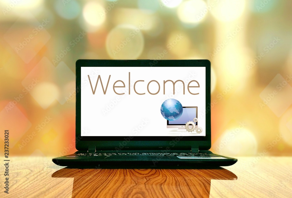 Fototapete black laptop with welcome text and computer graphic design in white screen on wooden table floor wit