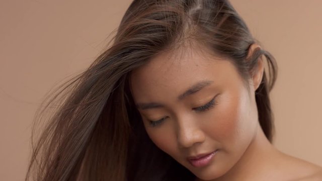closeup portrait of thai asian model with streaming in air straight hair slow motion from 60 fps