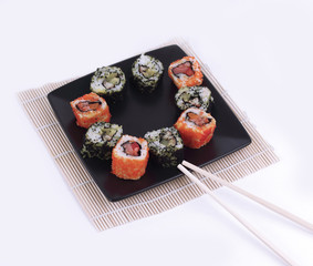 Sushi Set - different types of Maki sushi and chopsticks on a b