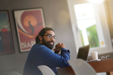 Hipster guy working from home on laptop