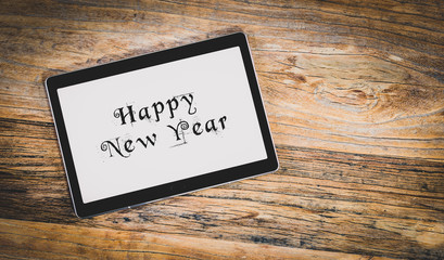Happy New Year on white tablet screen.