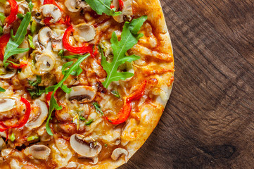 vegetarian Pizza with Mozzarella cheese, mushrooms, tomato sauce, pepper, Spices and Fresh arugula. Italian pizza on wooden table background