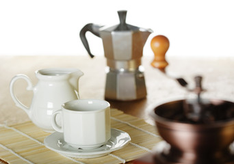Naklejka na ściany i meble Making coffee. Coffee grinder, cup, light background
