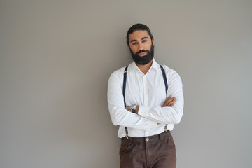 Hipster man with suspenders standing on background, isolated