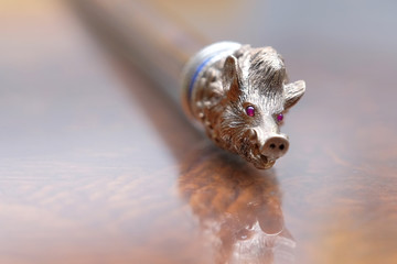 A cane with a boar's head rests on the table.