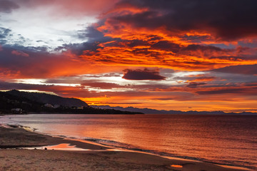 Fototapeta na wymiar Beautiful colorful sunset at the sea with dramatic clouds and sun shining