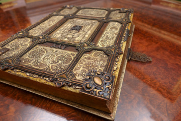  Antique book, with brass clasps on the old table. Medieval period of fantasy and religious concept.