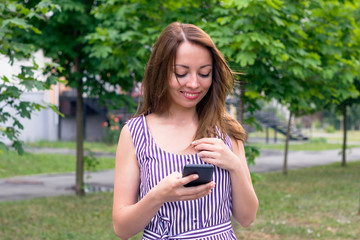 Naklejka premium Cheerful smiling girl using phone