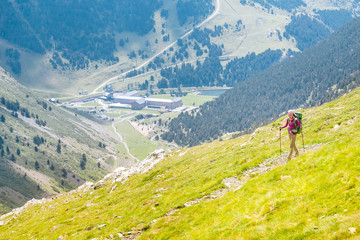 Fototapeta na wymiar hiker girl with poles walking at highland meadow