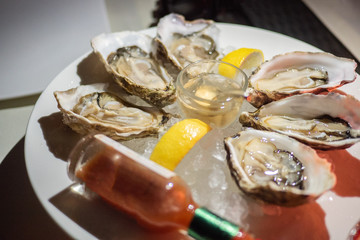 Tasty fresh shucked oysters on plate. Raw oysters are packed with nutrition, high in calcium, potassium, magnesium, vitamin and mineral. Flavor are sweet and refreshing. Believed to be an aphrodisiac.