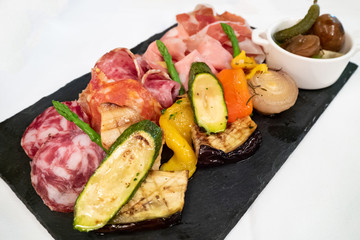 Assortment of tasty and delicious Italian Charcuterie antipasto delicatessen. Prosciutto di Parma or Parma ham, Salami sausage, Bologna, Chorizo and grilled vegetable. Perfect appetizer or party snack