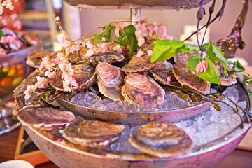 Tasty fresh oysters with flower decorate. Raw oysters are packed with nutrition, high in calcium, potassium, magnesium, vitamin and mineral. Flavor are sweet and refreshing. Believed to be aphrodisiac